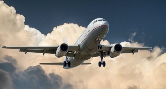 A commercial airplane flying through dramatic clouds, showcasing aviation in action.