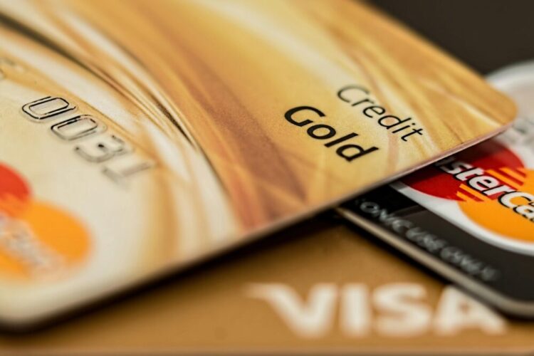 Stack of various branded credit cards focusing on gold card showing finance and cashless concept.